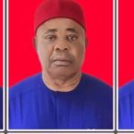 Ebonyi Commences Digitalisation of Land Management, Combats Grabbing Portrait of a man wearing a red cap and royal blue traditional outfit, against a bright red background.