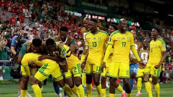 IMG_6614 Jamaican national soccer players in yellow celebrate on the field amid a cheering crowd.