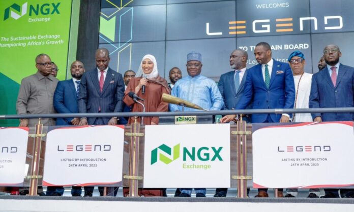 Legend-Internet-1000x600 Group of executives on stage at the NGX Exchange listing event; a woman in a hijab speaks into a microphone while colleagues stand beside her.