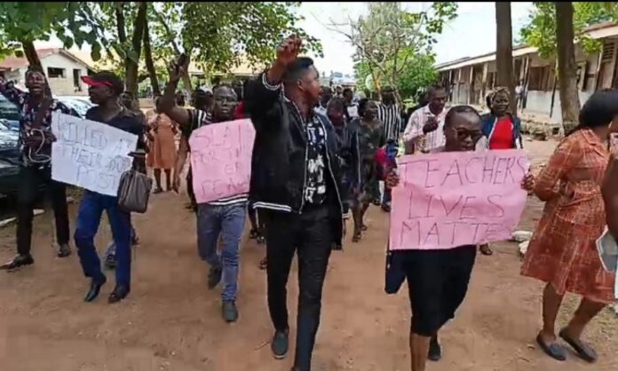 Oyo-abduction-1200x720 Protesters marching on a dirt road holding pink signs; main sign reads 'TEACHERS LIVES MATTER'