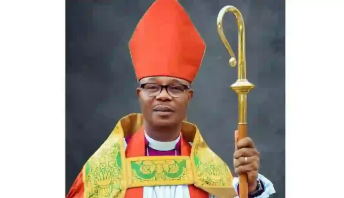 Rev-Chamberlain-Chinedum-Ogunedo Religious leader wearing a red mitre and ornate vestments, holding a gold crozier.