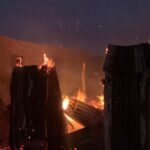 Repeated Hostel Fire Sparks Fear Over Students’ Safety In Bayelsa Medical University Nighttime scene of burning wooden debris and a brick wall, with large flames and glowing embers.