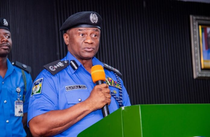 Tunji-Disu Police officer in blue uniform speaking into an orange microphone at a green podium, delivering a formal address.
