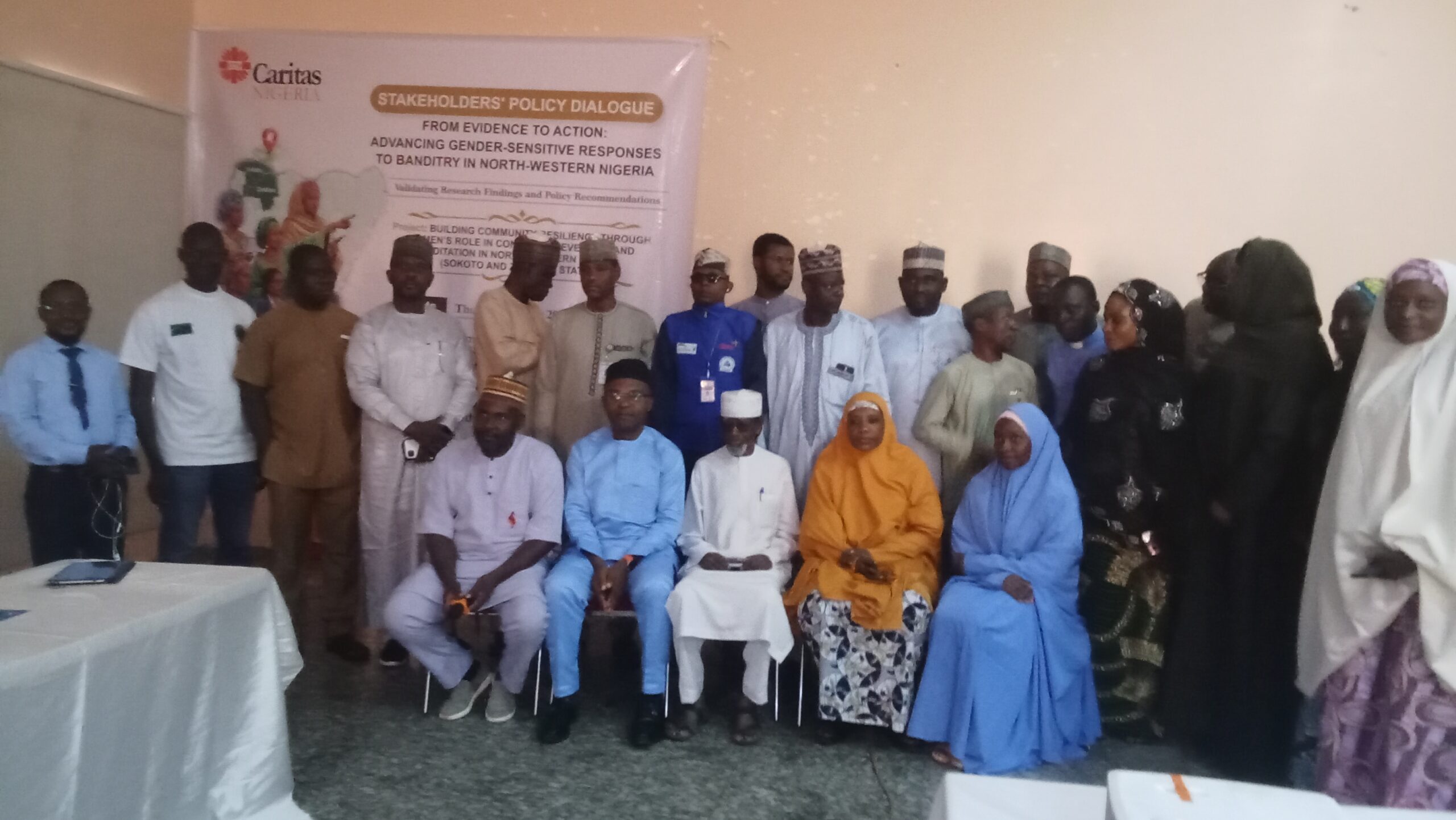 oplus_0 - THEWILL NEWS MEDIA Group of people in traditional attire posing for a photo at a stakeholder policy dialogue event.