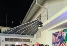 U.S. Mission Celebrates 250 Years Of American Independence In Lagos Group of formally dressed people posing for a photo at an event with US flags and a 'Freedom 250' backdrop at night