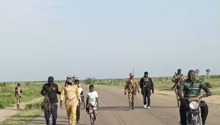 Troops of Operation HADIN KAI escort a suspected senior ISWAP finance operative and two children after his surrender along the Ladari–Jegarawa–Tunokalia axis on the Gamboru–Wulgo Main Supply Route in Borno State. The military said the operation formed part of a sustained offensive that has triggered a fresh wave of terrorist defections and led to the recovery of arms, ammunition, a motorcycle and cash. Photo: Operation HADIN KAI. - THEWILL NEWS MEDIA