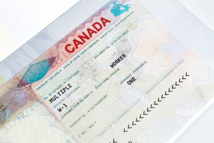 Canadian working visa in passport closeup. Immigration to Canada concept. Canadian working visa in passport closeup. Immigration to Canada concept.