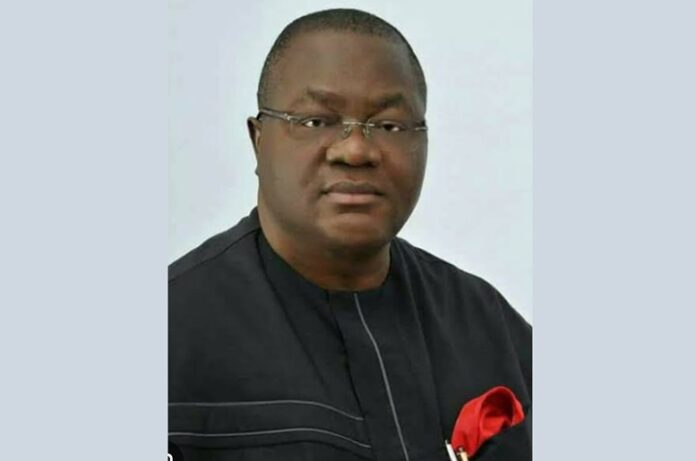 Effiong Bob Man in a black traditional outfit with a red pocket square, facing the camera.