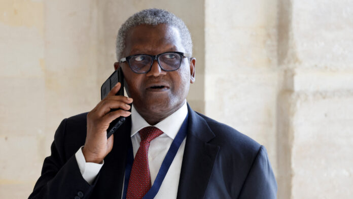 Nigerian multinational industrial conglomerate Dangote Group's CEO Aliko Dangote speaks on the phone as he attends the seventh "Choose France Summit". [Photo Credit: LUDOVIC MARIN/POOL/AFP via Getty Images]