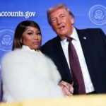 Donald Trump Praises Nicki Minaj, Calls Her “So Hot” Donald Trump and Cardi B pose together on a stage with a blue backdrop that reads TrumpCounts.gov and seals behind them.