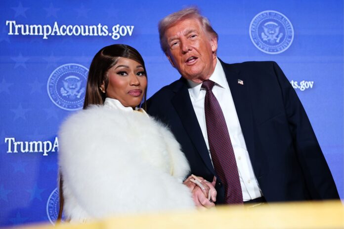 Trump and Nicki Donald Trump and Cardi B pose together on a stage with a blue backdrop that reads TrumpCounts.gov and seals behind them.