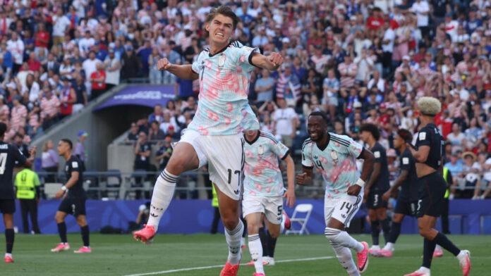 Belgium Outclass USA to Set Up World Cup Quarter-Final Clash with Spain Soccer players in light blue jerseys celebrate a goal on the field as a full stadium of fans cheers in the background.