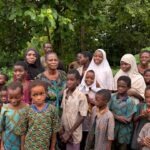 THEWILL EDITORIAL: After 56 days in Captivity, Time to Smile Again Group of African children and women standing together outdoors in a green, forested area.