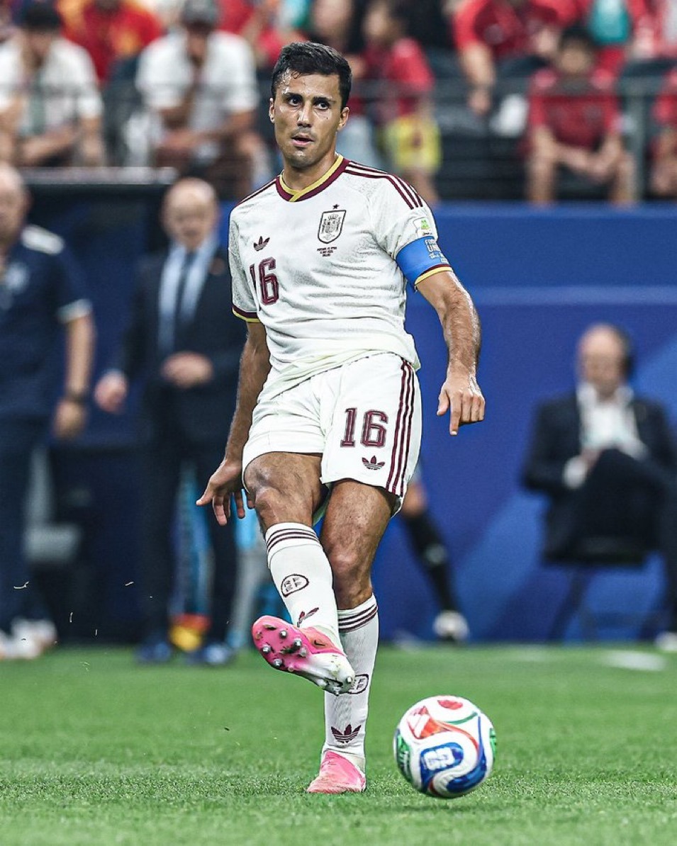 The midfield battle between Spain's playmakers and France's dynamic attackers could prove decisive in Tuesday's semifinal. - THEWILL NEWS MEDIA Soccer player in a white Spain jersey with number 16, kicking a ball on a green field during a match, blue captain's armband visible.