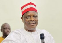2027: Kwankwaso Invokes Azikiwe, Ekwueme, Ojukwu To Push New North/South-East Alliance, Says Nigeria Must Choose Unity Over Division Man in white traditional attire holding a microphone, speaking at an event, red and white cap on his head.",
