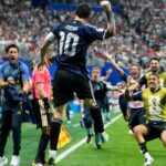 Messi Sparks Late Argentina Comeback to Break England’s Hearts, Set Up World Cup Final Against Spain Messi (number 10) leaps in celebration on a soccer field as photographers and teammates run toward him and a packed stadium cheers behind them.