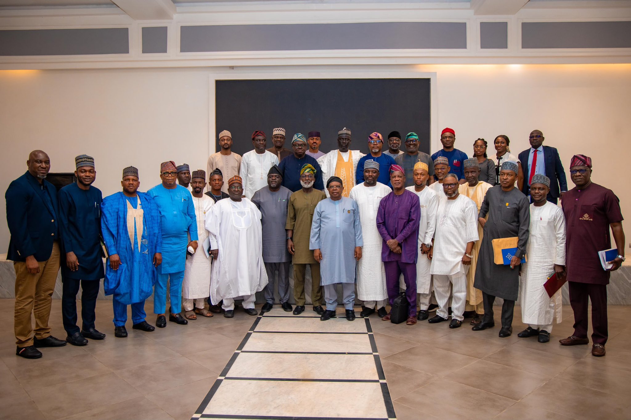 strengthen coordination on the implementation of the Electricity Act, 2023. - THEWILL NEWS MEDIA Group of Nigerian officials in colorful traditional attire posing for a formal group photo in a bright hall.