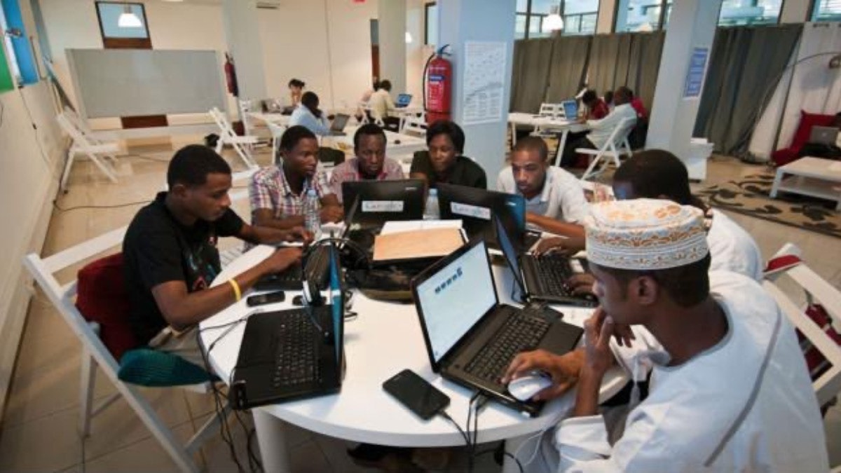 A representation of a start-up company. Photocredit: Tekedia - THEWILL NEWS MEDIA Group of diverse young people collaborating on laptops around a round table in a bright open coworking space.