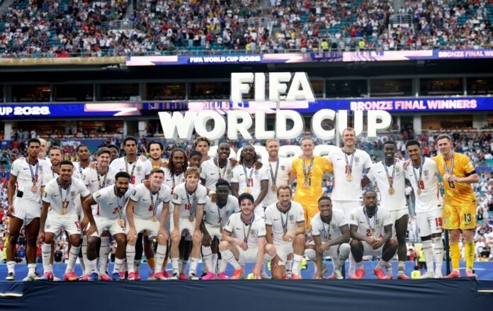 England celebrate after defeating France 6-4 in a breathtaking FIFA World Cup 2026 third-place playoff. Credit: Getty image England football team pose with medals on a podium after winning bronze at the FIFA World Cup 2026, with fans in the stadium behind.
