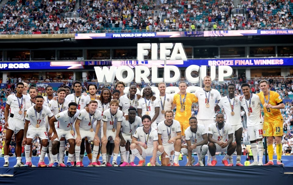 England celebrate after defeating France 6-4 in a breathtaking FIFA World Cup 2026 third-place playoff. Credit: Getty image - THEWILL NEWS MEDIA England football team pose with medals on a podium after winning bronze at the FIFA World Cup 2026, with fans in the stadium behind.
