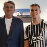 From World Cup Hero to Arsenal Exit: The Twist Nobody Expected for Leandro Trossard BeÅŸiktaÅŸ footballer in a black-and-white striped jersey posing with a man in a suit indoors.