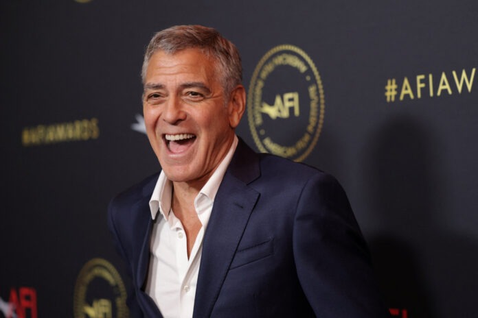Smiling man in a navy suit photographed at an event with a dark backdrop and gold AFI branding behind him.