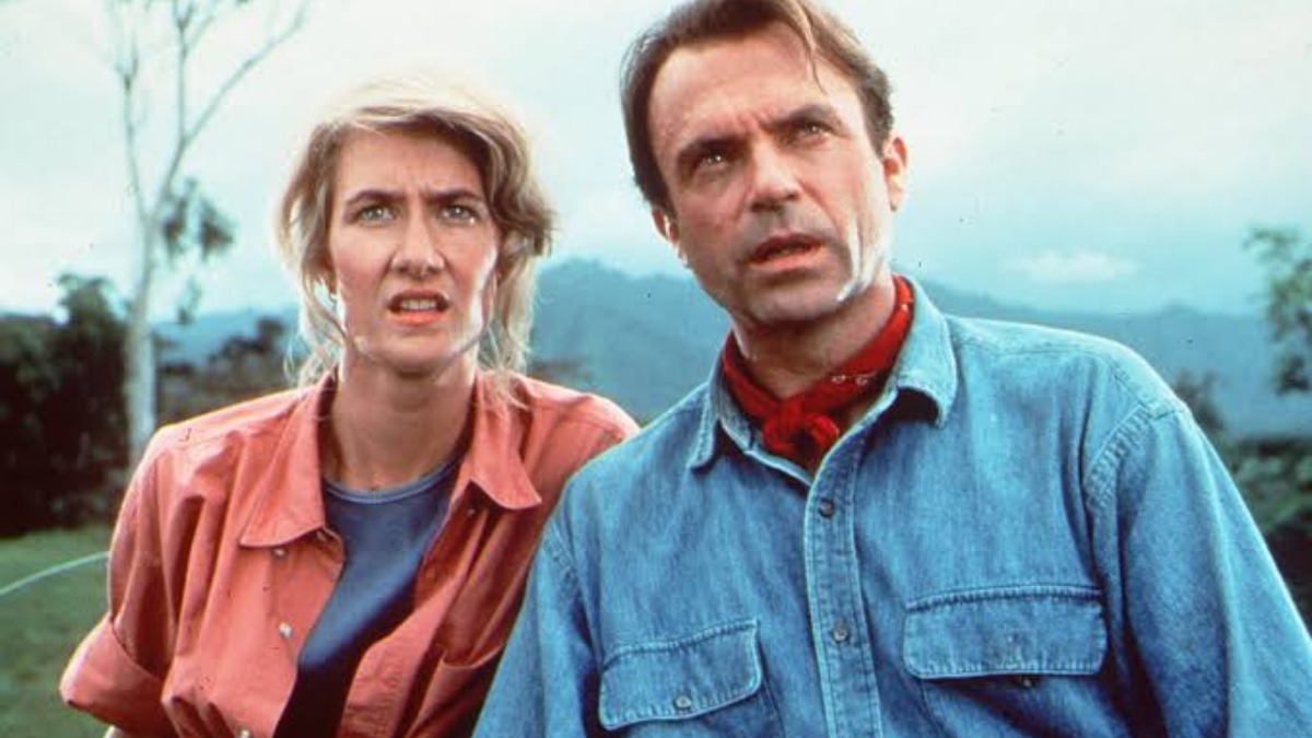 sam neill 2 - THEWILL NEWS MEDIA Two adults outdoors with surprised expressions, standing in a grassy, hilly landscape.