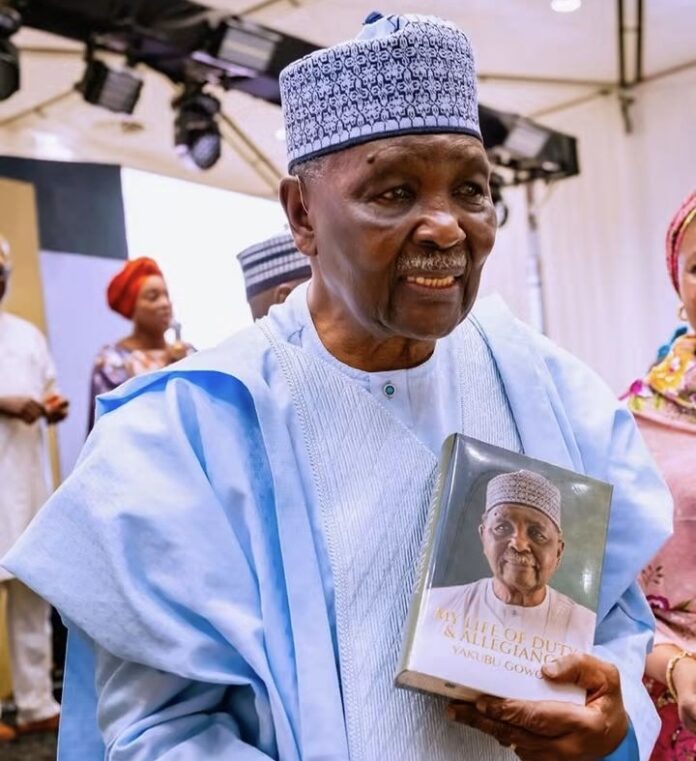 Former Military Head of State, Gen. Yakubu Gowon, displays a copy of his memoir, ‘My Life of Duty and Allegiance’.